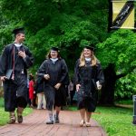 Graduates walk along the Red Brick Path on front campus