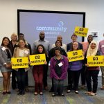 Students and Community Foundation for a Greater Richmond staff pose with signs that read, "Go WildCats!"