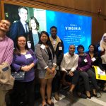 Students pose in front of an electronic sign at Governor Ralph Northam
