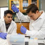 Eynnar Claros Chacon (left) and Allen Vaytser extract DNA samples in the lab