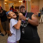 A student and servant-leader intern dance together
