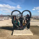 Students pose with a heart-shaped statue
