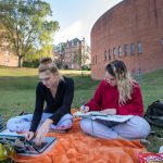 Students study on the lawn next to the Houston Memorial Chapel