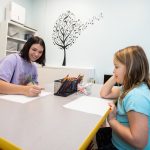 Cassidy Carter draws with the daughter of psychology professor Sara Beck in the new children