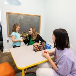 Psychology professor Sara Beck and her daughter work with Cassidy Carter in the new children