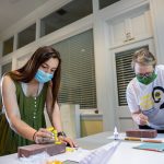 Sabrina Johnson ' and education professor Cheryl Lindeman paint bricks to kick off the Summer Research Program last month. Each student and faculty member was sent a brick to paint as part of the program's 2020 theme, Beyond the Red Brick Wall.