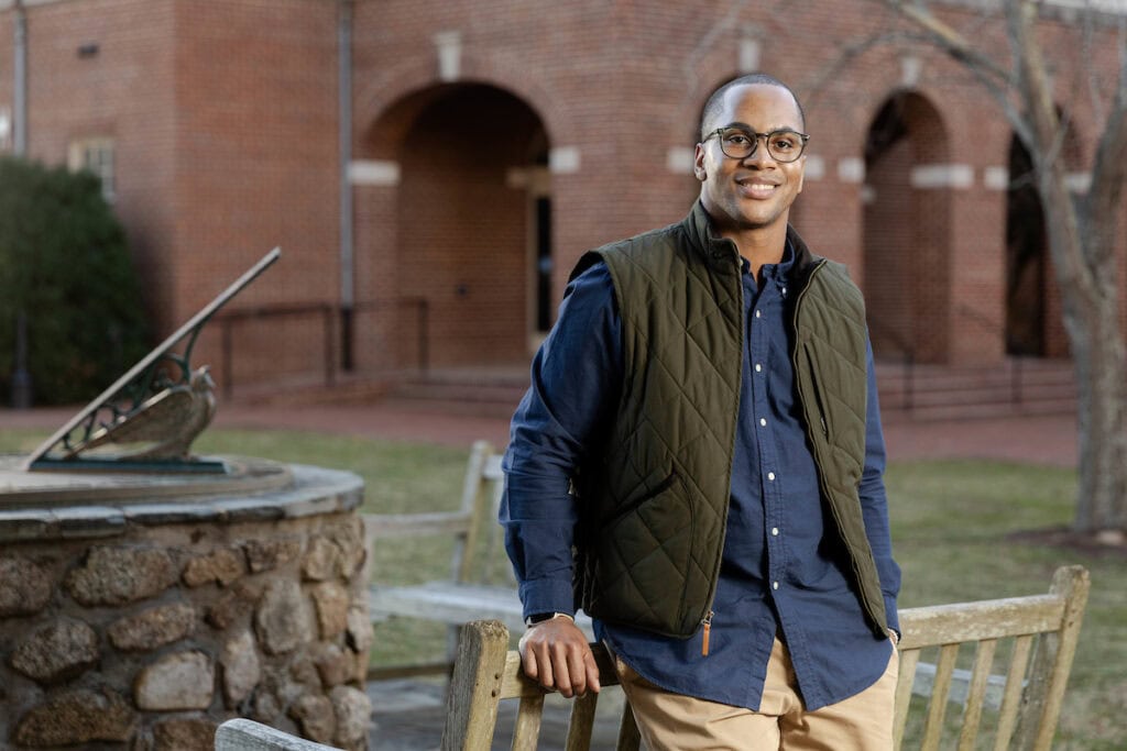 Carl Coffey poses in front of a bench on campus.