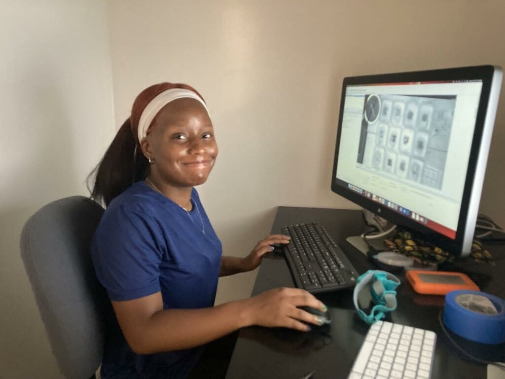 Quianday Worthington smiles while working at a computer