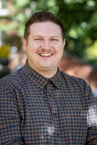 Portrait photo of Dustin Abernathy outside on front campus