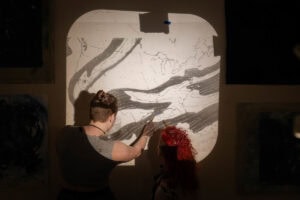 Artist Ann Holsberry works with students to install her work 