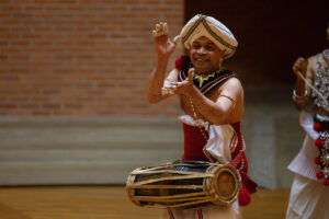 Chinthaka Bandara, wearing a drum around his waist, claps his hands during a performance in Houston Memorial Chapel.
