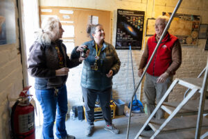 A group of volunteers installs a new telescope inside Winfree Observatory