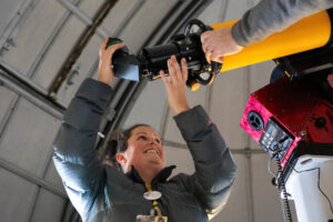 A group of volunteers installs a new telescope inside Winfree Observatory