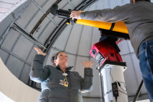 A group of volunteers installs a new telescope inside Winfree Observatory