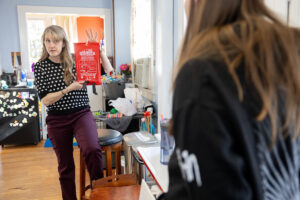 Karin Warren holds up a fire blanket, showing students what it looks like.