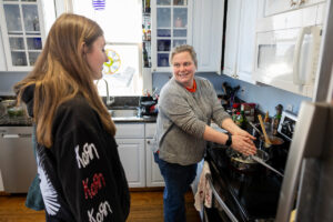 Sarah Sojka cooks on the stovetop as one of her students looks on.