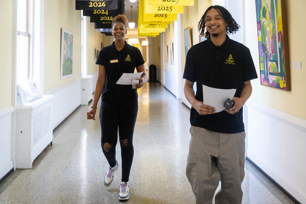 Nafi Thiam and Cameron Goulde walk down a hallway in Main Hall.