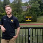Zach Nipper poses for a photo in front of the Randolph soccer field.