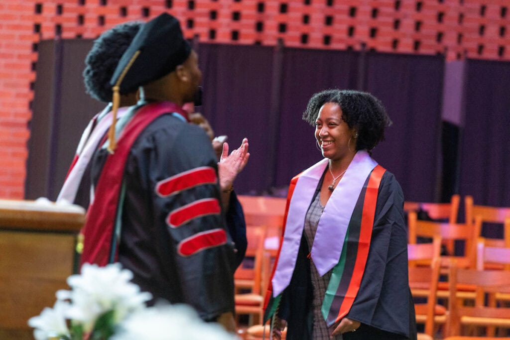 Jordyn Shumpert walks up to the stage during Randolph's 2025 Intercultural Baccalaurate. The event was held in Houston Memorial Chapel, which you can see in the background. She's smiling. Jordyn Shumpert walks up to the stage during Randolph's 2025 Intercultural Baccalaurate. The event was held in Houston Memorial Chapel, which you can see in the background. She's smiling.