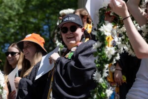 A group of students laugh while singing during the Daisy Chain ceremony 
