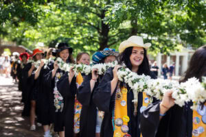 Students from the Class of 2025 walk while holding the Daisy Chain
