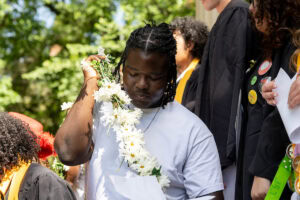 A sophomore holds the Daisy Chain as he walks across campus