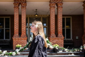A student from the Class of 2025 walks while holding the Daisy Chain