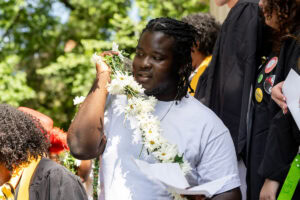 A sophomore holds the Daisy Chain as he walks across campus