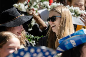 Two students smile and laugh together during Daisy Chain