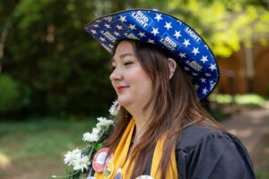 A student from the Class of 2025 walks while holding the Daisy Chain