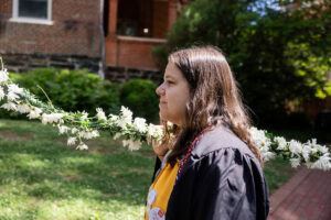 A student from the Class of 2025 walks while holding the Daisy Chain