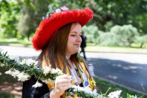 A student from the Class of 2025 walks while holding the Daisy Chain