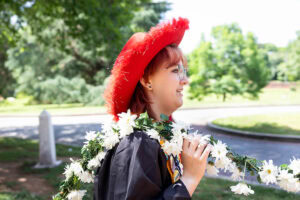 A student from the Class of 2025 walks while holding the Daisy Chain