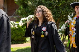 A student from the Class of 2025 walks while holding the Daisy Chain