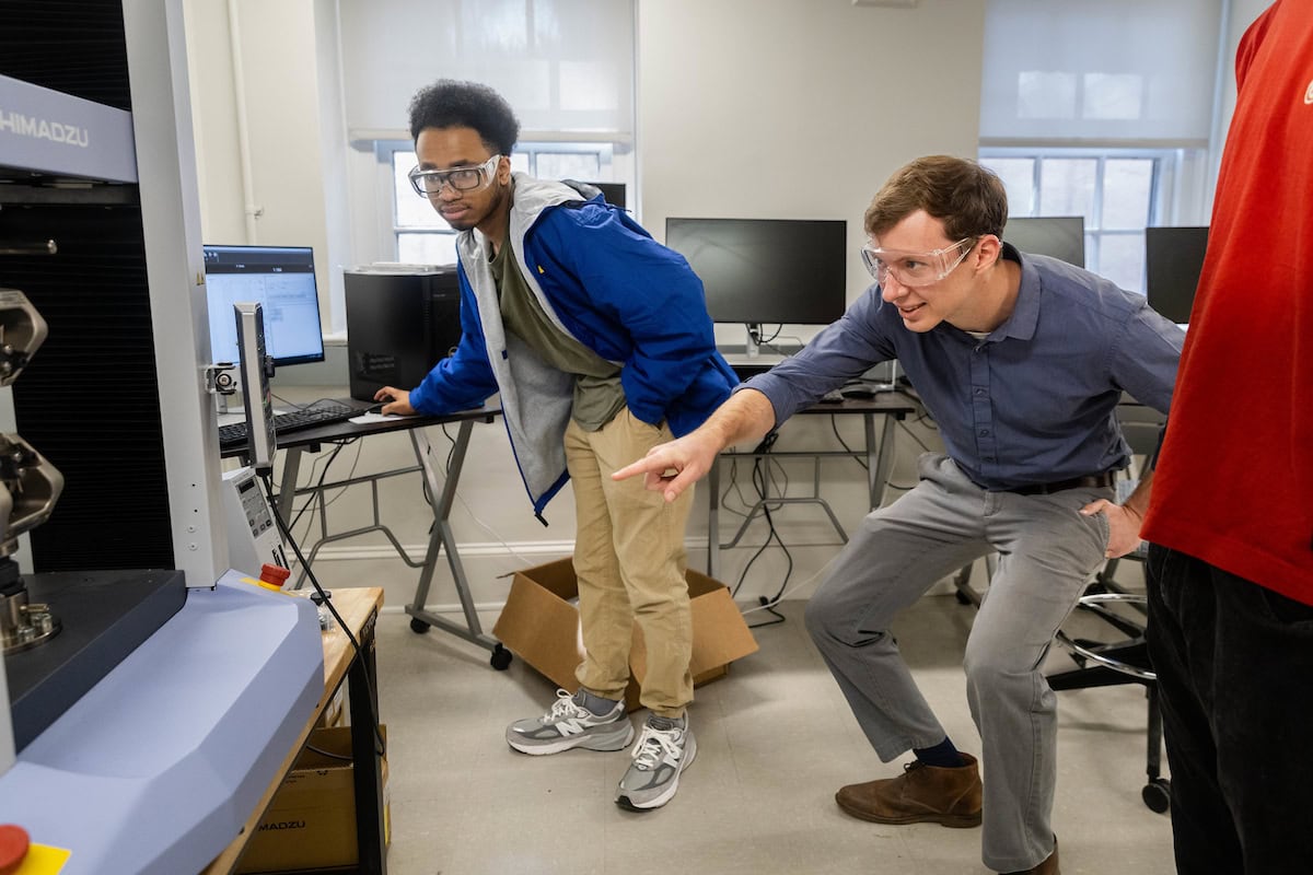 Andrew Hooks and professor Jonathan Skelton look and point at the College's 3D printer 