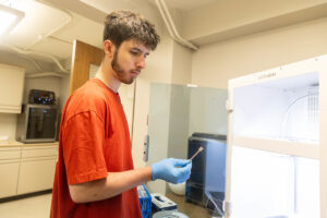 Kyle Thompson looks at a sample after it comes out of a 3D printer