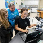 Erin Winslow, professor Sarah Sojka, and Olivia Lorenzo gather around a laptop in the environmental science lab. Erin Winslow, professor Sarah Sojka, and Olivia Lorenzo gather around a laptop in the environmental science lab.