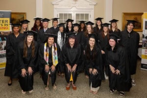 A group of Master of Arts in Teaching and Master of Education graduates pose together for a photo 
