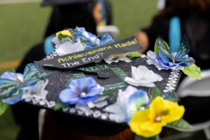 A close-up of a decorated cap, with flowers and gemstones 