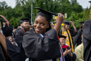 A student smiles as she moves her tassel during Commencement 