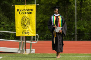A graduate smiles after exiting the Commencement stage