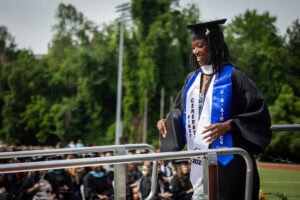 A graduate smiles after exiting the Commencement stage