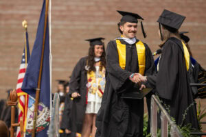 A student shakes hands onstage during Commencement
