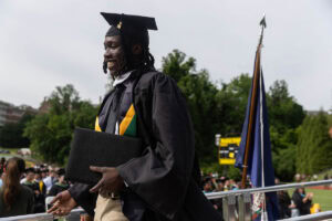 A graduate smiles after exiting the Commencement stage