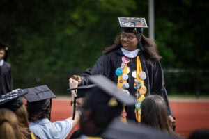 A graduate smiles after exiting the Commencement stage