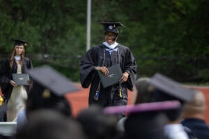 A graduate smiles after exiting the Commencement stage