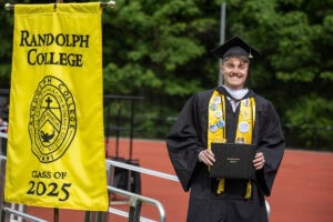 A graduate smiles after exiting the Commencement stage