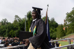 A graduate smiles after exiting the Commencement stage