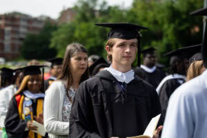 A student in cap and gown in the crowd during Commencement 