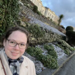 Elizabeth Bailey poses for selfie in front of the National Library of Wales while conducting research there